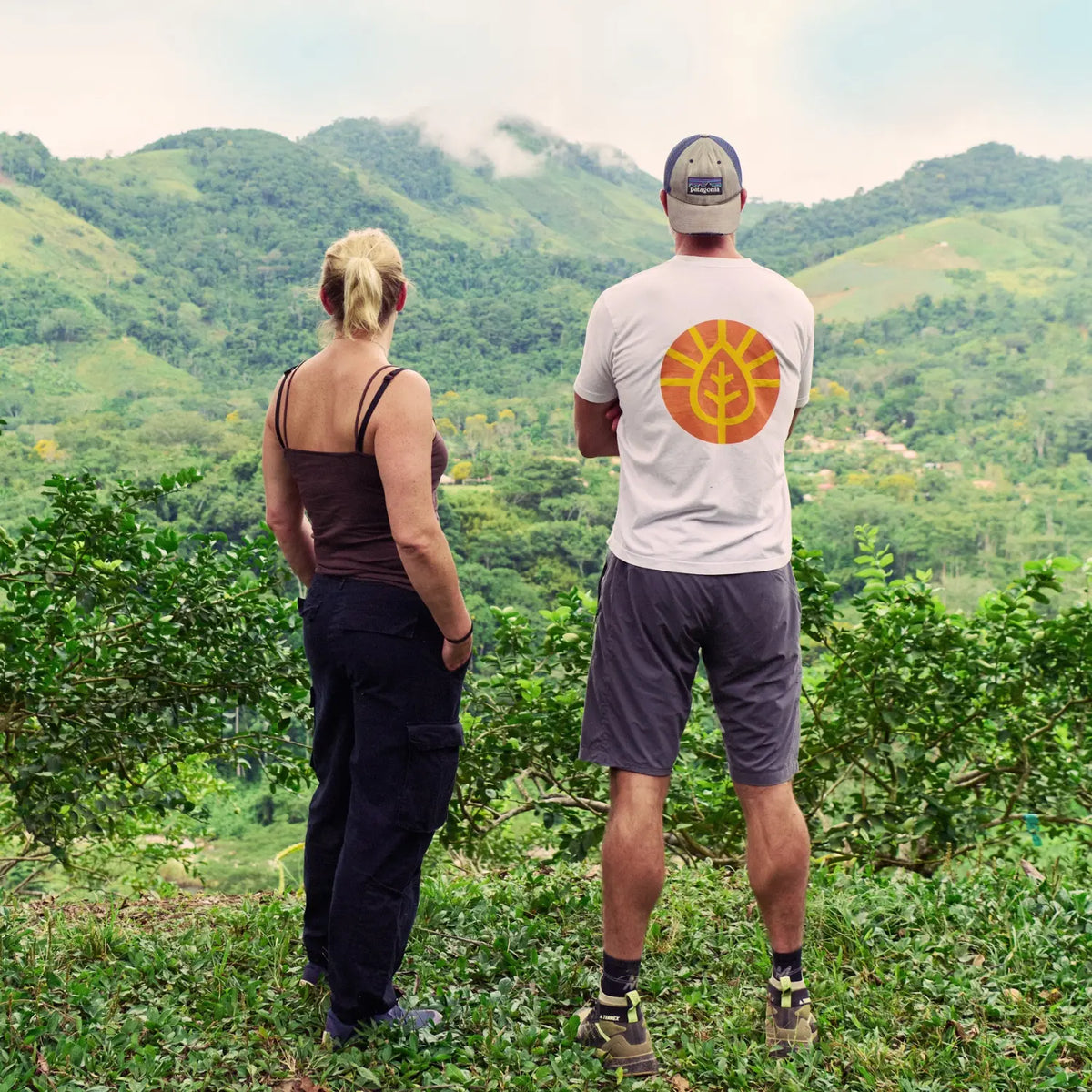 Rich and Nella from MOJUm standing on a hillside in Peur overlooking mountains, where ginger and turmeric are grown.